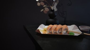 Bir tabak taze karides suşi, üzerine sos, zencefil ve wasabi serpiştirilmiş..