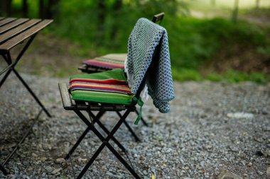 Ahşap sandalye ve açık masa renkli yastıklar, rahat bir yer yaratıyor..