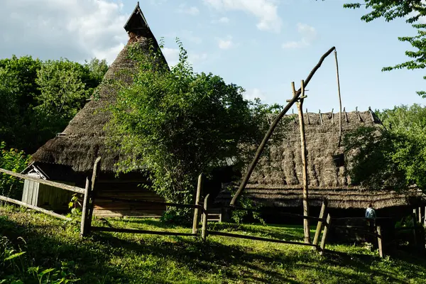Geleneksel sazdan çatı evleri doğa ve basit ahşap çitlerle çevrili.
