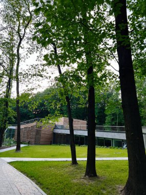 Lviv, Ukrayna - 24 Haziran 2025: Çağdaş bir bina yemyeşil manzaralı bir parka uyum içinde entegre edildi.