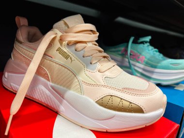 Kyiv, Ukrayna - 24 Haziran 2025: Yüzeyde sergilenen konfor ve tarzı yansıtan bej rengi Puma ayakkabı renklendirme.
