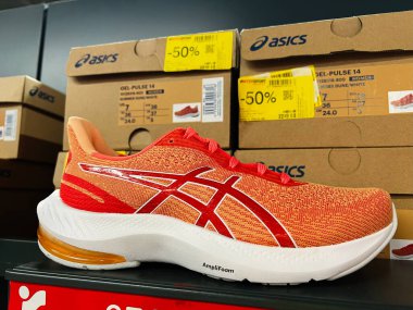 Kyiv, Ukrayna - 24 Haziran 2025: Turuncu ve beyaz Atletizm ayakkabıları kutularla dolu bir mağaza ortamında öne çıktı