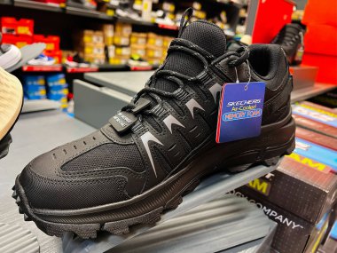 Kyiv, Ukrayna - 24 Haziran 2025: Bir perakende mağazasında sergilenen köpük teknolojili siyah bir Skechers ayakkabısı 