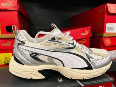 Kyiv, Ukrayna - 24 Haziran 2025: Beyaz ve siyah Puma atletik ayakkabıları kırmızı kutularla çevrili bir perakende rafının üstüne yerleştirildi