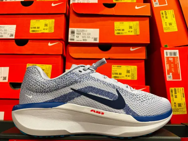 Kyiv, Ukrayna - 24 Haziran 2025: Nike marka renkli ayakkabı kutularının önünde sergilenen beyaz bir spor ayakkabısı