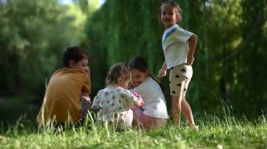 Dört mutlu çocuk güzel güneşli bir günün tadını çıkarıyorlar, renkli sabun köpükleriyle oynuyorlar..