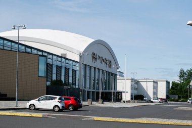 Reykjavik, İzlanda - 28 Haziran 2025: Reykjavik, İzlanda 'da park halindeki arabaların bulunduğu modern bir eğlence tesisi Laugardalsholl Spor Merkezi