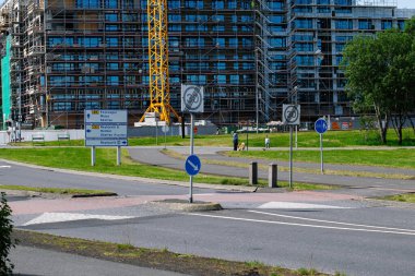 Reykjavik, İzlanda - 28 Haziran 2025: Reykjavik 'te yol, vinç, tabela ve yeşil çevreye sahip inşaat alanı.