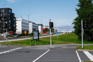 Reykjavik, İzlanda - 28 Haziran 2025: Açık gökyüzü altında trafik ışıkları, bisiklet yolları ve yeşillik ile modern bir kavşak.