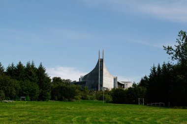 Reykjavik, İzlanda 'da, açık mavi gökyüzünün altında yemyeşil bir doğa içine kurulmuş çarpışma mimarisi.