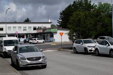 Reykjavik, İzlanda - 05 Temmuz 2025: Reykjavik, İzlanda 'da park halindeki araçlar ve küçük yerel işletmelerin yer aldığı şehir manzarası