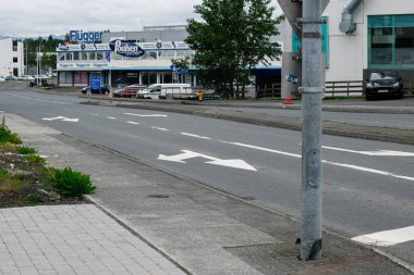 Reykjavik, İzlanda - 05 Temmuz 2025: Reykjavik, İzlanda 'da bulutlu gökyüzü altında binalar ve karayolunun yer aldığı şehir manzarası.