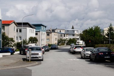 Reykjavik, İzlanda - 05 Temmuz 2025: Reykjavik, İzlanda 'da şehir evleri ve park halindeki araçların yer aldığı sessiz mahalle.