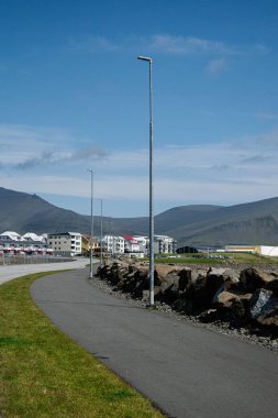 Akranes, İzlanda 'da yerleşim yerleri ve dağların yanındaki sokak lambalarıyla dolu bir yol..