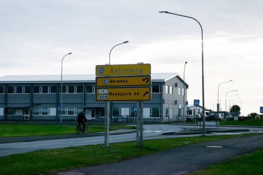 Yol göstergeli sokak manzarası ve Akranes, İzlanda 'da bir bisikletçi.