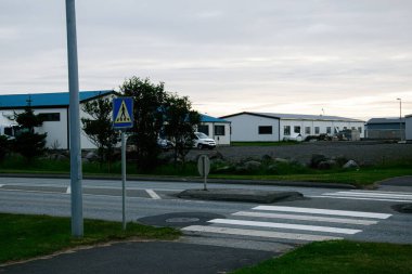 Akranes, İzlanda 'da bulutlu bir günde sanayi binalarının yanında yaya geçidi