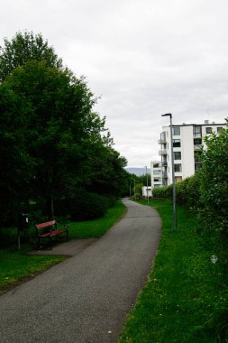 Reykjavik, İzlanda 'da yeşil çevre, bank ve modern binalarla dolu bir patika.