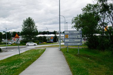 Reykjavik, İzlanda 'da kavşağın ve binaların yakınındaki yol işaretlerine çıkıyor.