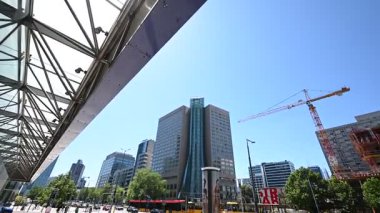 Varşova, Polonya - 02 Temmuz 2025: Modern mimari, hareketli trafik ve Polonya 'nın güneşli Varşova kentinde yayalar ile canlı şehir caddesi.