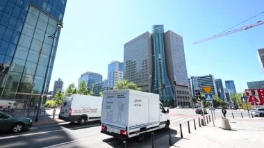 Varşova, Polonya - 2 Temmuz 2025: Dinamik sokak görüşü, Polonya 'nın Varşova kentinde yükselen modern Q22 mimarisi ve aktif kentsel yaşam içeriyor.