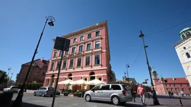 Varşova, Polonya - 02 Temmuz 2025: Canlı sokak yaşamı ve Polonya 'nın güneşli Varşova kentindeki tarihi binalar, arabalar ve yayalar.