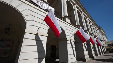 Polonya 'nın merkezindeki Varşova' da canlı kırmızı ve beyaz Polonya bayrakları dekoratif bir mimari cepheyi süslüyor.
