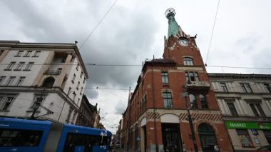 Krakow, Polonya - 08 Temmuz 2025: Krakow, Polonya 'da dinamik sokak yaşamı, modern bir tramvay ve tarihi şehir mimarisi Dom Pod Globusem' i sergilemektedir.