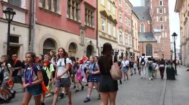 Krakow, Polonya - 08 Temmuz 2025: Turistler, çocuklar ve yerliler Polonya 'nın Krakow kentindeki güzel tarihi bir cadde boyunca yürüyüp şehir atmosferinin tadını çıkarıyorlar.