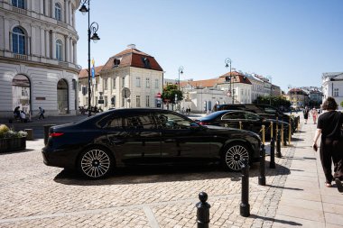 Varşova, Polonya - 02 Temmuz 2025: Varşova 'nın kentsel ortamında güneşli bir günde ele geçirilen lüks arabalar.