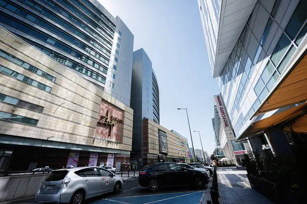 Varşova, Polonya - 02 Temmuz 2025: Polonya 'nın Varşova kentinde Zlote Tarasy' nin kurulması, çağdaş binalar ve sokak kenarındaki park alanlarının yer alması