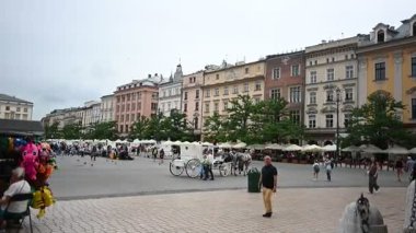 Krakow, Polonya - 08 Temmuz 2025: Polonya 'nın tarihi Ana Pazar Meydanı Krakow' daki günlük yaşamın hareketli bir görüntüsü, insanlarla dolu.