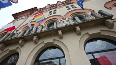 Krakow, Polonya - 08 Temmuz 2025: Polonya 'nın Krakow kentindeki tarihi bir binada, çeşitliliği ve mirası temsil eden sembolik bayraklar.