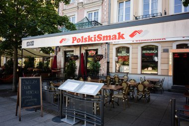 Varşova, Polonya - 2 Temmuz 2025: Varşova 'da Polski Smak adlı Polonya tarzı restoran açık hava oturma ve geleneksel menü sunumları sunuyor.