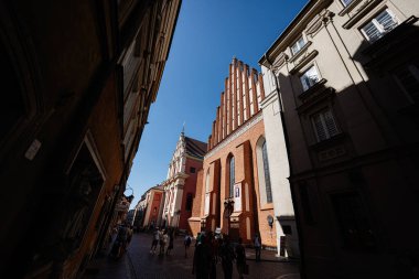 Varşova, Polonya - 2 Temmuz 2025: Varşova, Polonya 'da eski bir kasaba sokağının yanında tarihi bir St John Katedrali.