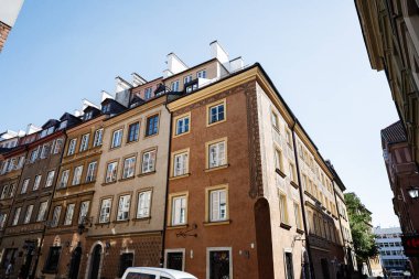 Varşova, Polonya - 02 Temmuz 2025: Varşova, Polonya 'daki konut binalarının geleneksel mimarisi, parlak bir gökyüzüne karşı