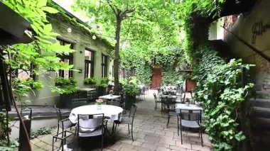 Krakow, Polonya - 8 Temmuz 2025: Polonya 'nın Krakow kentindeki büyüleyici bir restoran avlusunda boş ve huzurlu bir açık hava yemek alanı.