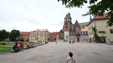 Krakow, Polonya - 8 Temmuz 2025: İnsanlar rahatlayıp Polonya 'nın Krakow kentindeki Wawel Kraliyet Kalesi' nin geniş avlusunu keşfediyorlar..