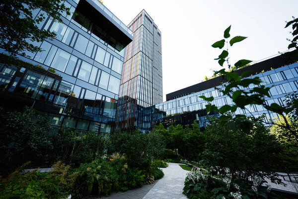 Современные стеклянные здания с ландшафтной растительностью демонстрируют современный городской дизайн