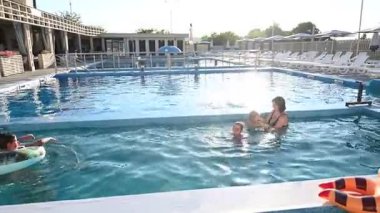 Aile, yaz tatilinde havuzda eğlenmeyi ve yüzmeyi sever..