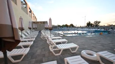 Açık havuzu güneşli ve şemsiyeli havuz alanına davet etmek, yaz tatili için mükemmel..