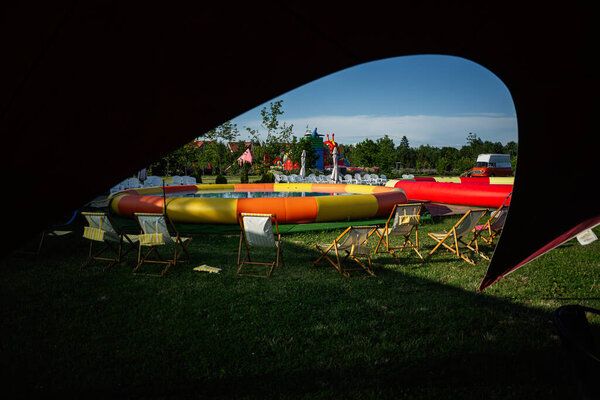 Large inflatable play area surrounded by deck chairs under outdoor open sky
