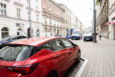 Krakow, Polonya - 08 Temmuz 2025: Polonya 'nın Krakow kentinde park halindeki araçlar, tarihi binalar ve şehir trafiğinin yer aldığı şehir manzarası