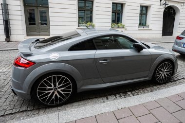 Krakow, Polonya - 08 Temmuz 2025: Gri spor Audi TT RS coupe zarif bir şekilde Polonya 'nın tarihi Krakow kentindeki kaldırım taşı sokağına park etti