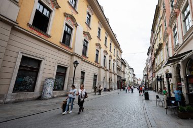 Krakow, Polonya - 08 Temmuz 2025: Polonya 'nın Krakow şehrinde yayalar ve tarihi mimarilerle dolu yoğun bir cadde.