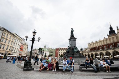 Krakow, Polonya - 8 Temmuz 2025: Krakow 'un halk, tarihi mimari ve ikonik heykellerle dolu ana meydanı.