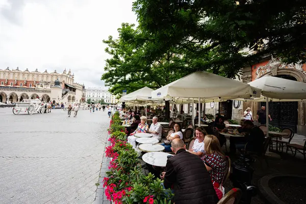 Krakow, Polonya - 08 Temmuz 2025: Krakow Polonya 'daki tarihi açık kafe, hareketli çevreyle gevşek bir ortam sergiliyor
