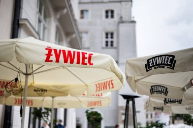Krakow, Polonya - 8 Temmuz 2025: Polonya 'nın Krakow kentindeki açık hava avlusunda markalı Zywiec bira şemsiyeli kafe