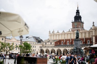Krakow, Polonya - 8 Temmuz 2025: Aktif turistler güzel mimari ve eserlerin yer aldığı Krakow ana meydanını keşfediyorlar