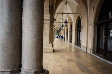 Krakow, Polonya - 08 Temmuz 2025: Polonya 'nın Krakow kentinde taş sütunlar ve fenerlerle tarihi kemer yolu