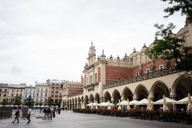 Krakow, Polonya - 08 Temmuz 2025: Polonya 'nın Krakow şehrinde mimari bir dönüm noktası meydanda canlı kafeler sergiliyor